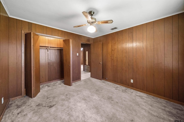 unfurnished bedroom featuring a closet, ornamental molding, visible vents, and light colored carpet
