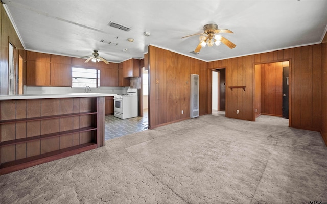 kitchen featuring white gas range oven, crown molding, a ceiling fan, brown cabinetry, and visible vents