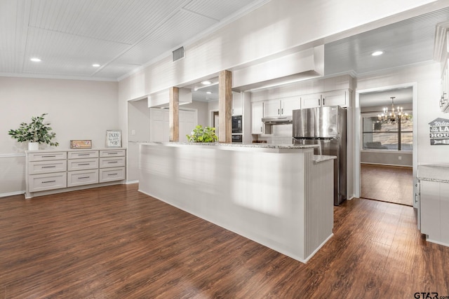 kitchen featuring white cabinetry, dark wood-type flooring, light stone counters, kitchen peninsula, and stainless steel fridge