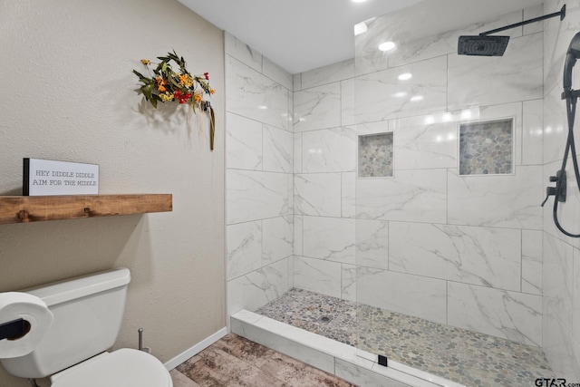 bathroom featuring toilet and tiled shower