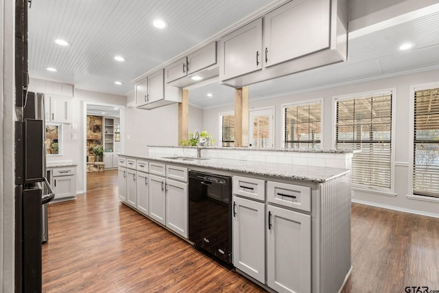 kitchen featuring dishwasher, sink, light stone countertops, ornamental molding, and dark hardwood / wood-style flooring