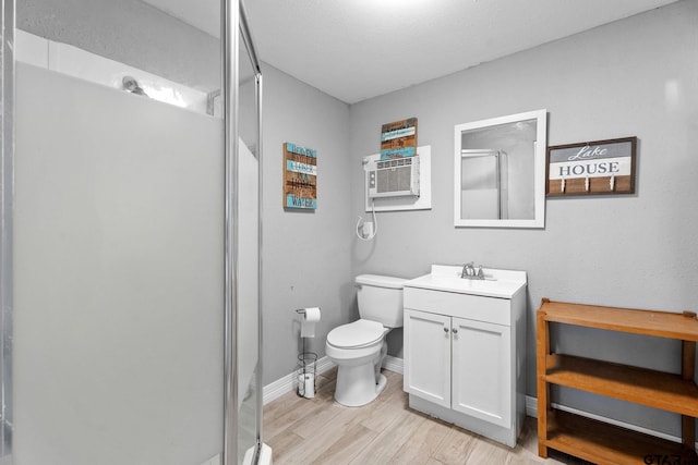 bathroom with hardwood / wood-style floors, vanity, toilet, and walk in shower