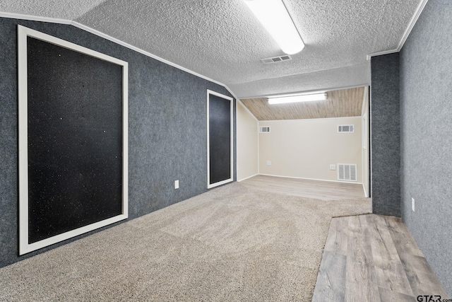 empty room featuring ornamental molding, carpet floors, and lofted ceiling