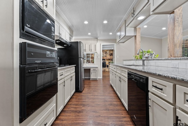 kitchen with light stone countertops, sink, white cabinets, and black appliances