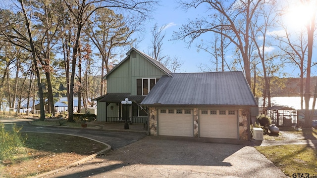 view of front facade featuring covered porch, a garage, and a water view