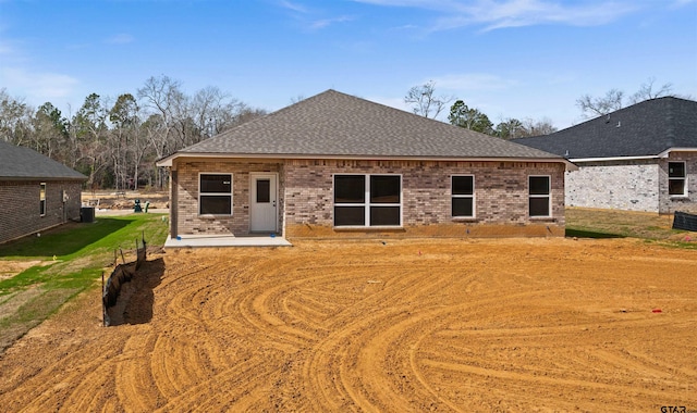 16221 Crossing Cir, Lindale, TX 75771 - rear view of house featuring brick siding, a shingled roof, and a patio area