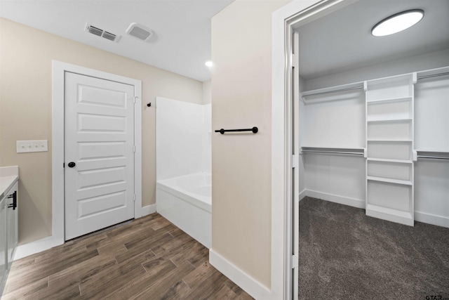 16221 Crossing Cir, Lindale, TX 75771 - bathroom featuring vanity, wood finished floors, a spacious closet, and bathtub / shower combination