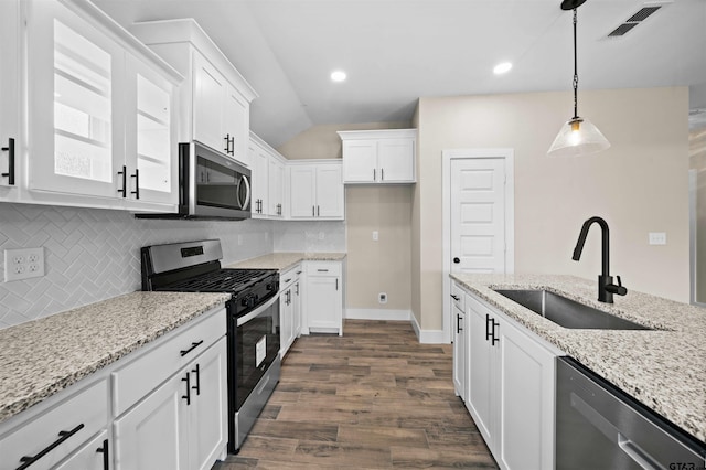 16221 Crossing Cir, Lindale, TX 75771 - kitchen with appliances with stainless steel finishes, tasteful backsplash, white cabinetry, dark wood-type flooring, and vaulted ceiling