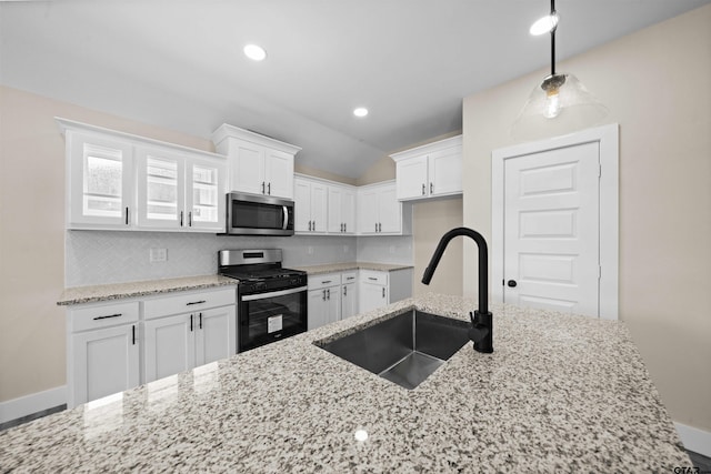 16221 Crossing Cir, Lindale, TX 75771 - kitchen with stainless steel appliances, light stone counters, white cabinetry, lofted ceiling, and tasteful backsplash