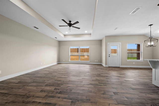16221 Crossing Cir, Lindale, TX 75771 - unfurnished living room with a ceiling fan, dark wood-style flooring, a chandelier, recessed lighting, and a tray ceiling