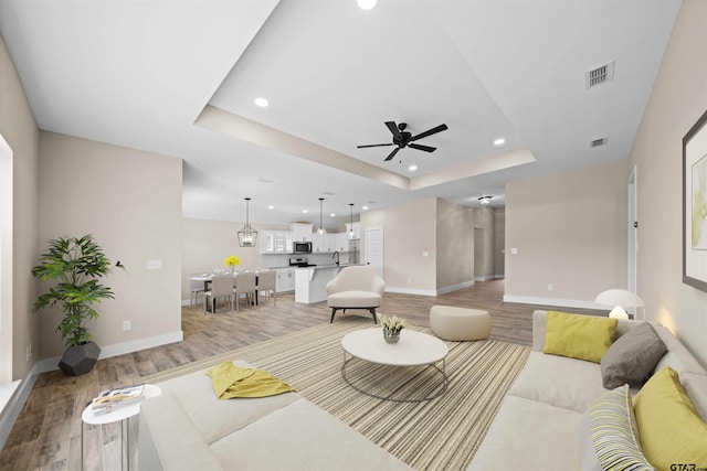 16221 Crossing Cir, Lindale, TX 75771 - living area featuring light wood finished floors, ceiling fan, recessed lighting, and a raised ceiling