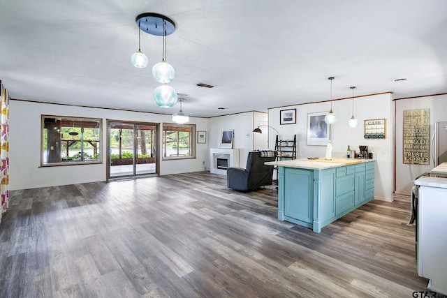 488 Omaha Dr, Omaha, TX 75571 - kitchen featuring blue cabinets, open floor plan, wood finished floors, light countertops, and decorative light fixtures