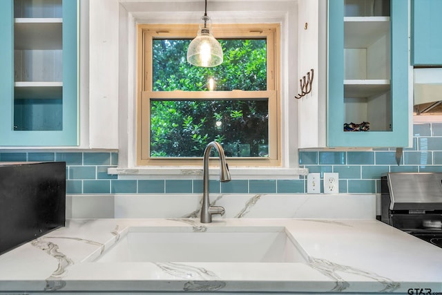 488 Omaha Dr, Omaha, TX 75571 - kitchen featuring a sink, glass insert cabinets, pendant lighting, and backsplash