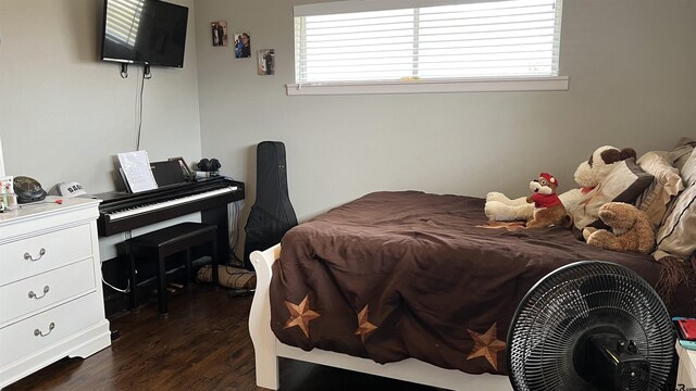 bedroom with dark wood-style flooring and multiple windows