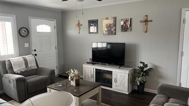 living room with a ceiling fan, crown molding, dark wood finished floors, and baseboards