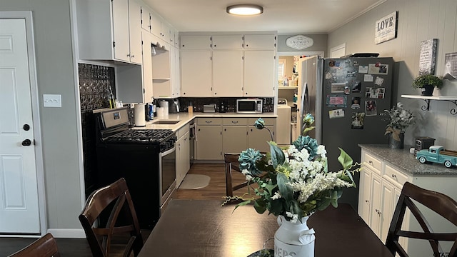 kitchen featuring tasteful backsplash, white cabinetry, appliances with stainless steel finishes, and light countertops