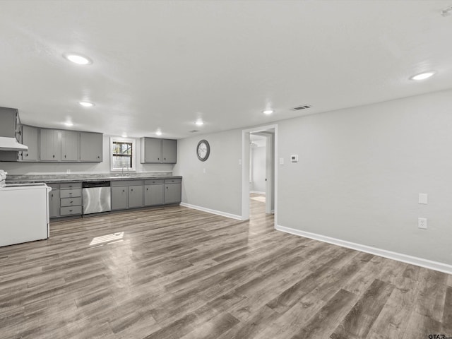 kitchen with gray cabinetry, stainless steel dishwasher, hardwood / wood-style floors, electric stove, and exhaust hood