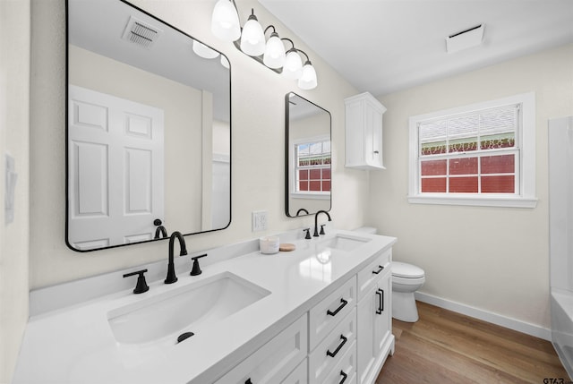 912 S Palmer Ave, Tyler, TX 75701 - bathroom featuring double vanity and wood finished floors