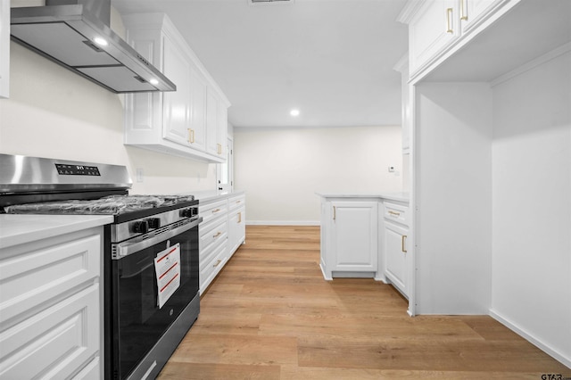912 S Palmer Ave, Tyler, TX 75701 - kitchen with stainless steel range with gas stovetop, wall chimney range hood, white cabinets, light countertops, and recessed lighting