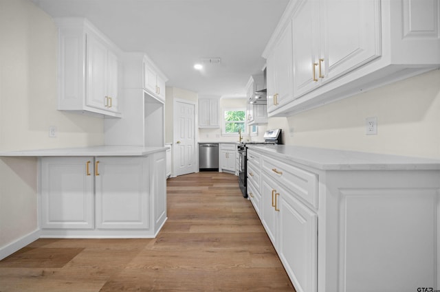 912 S Palmer Ave, Tyler, TX 75701 - kitchen with stainless steel appliances, white cabinetry, light wood-style floors, a peninsula, and light countertops