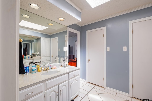 bathroom featuring a skylight, recessed lighting, ornamental molding, vanity, and tile patterned flooring