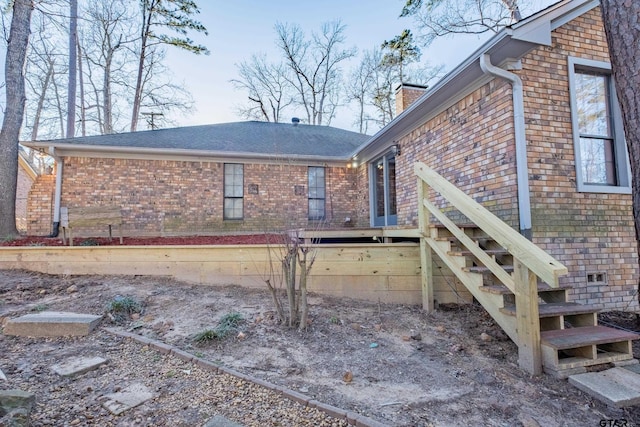 view of home's exterior featuring a chimney and brick siding