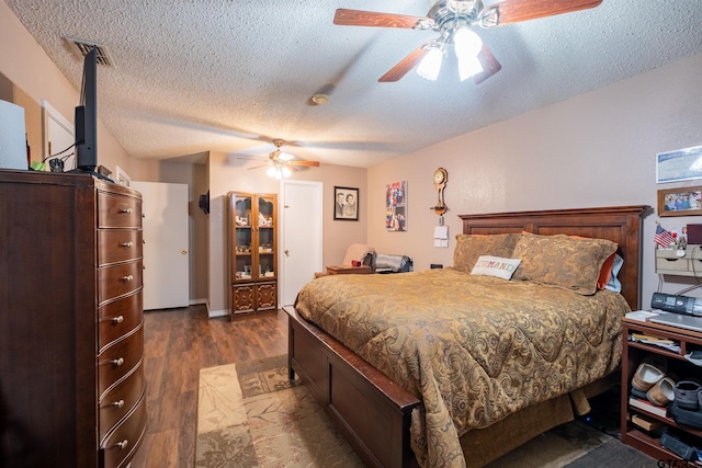 bedroom with dark wood-style floors, visible vents, a ceiling fan, and a textured ceiling