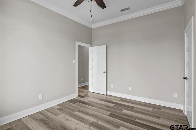 empty room with ceiling fan, hardwood / wood-style flooring, and ornamental molding