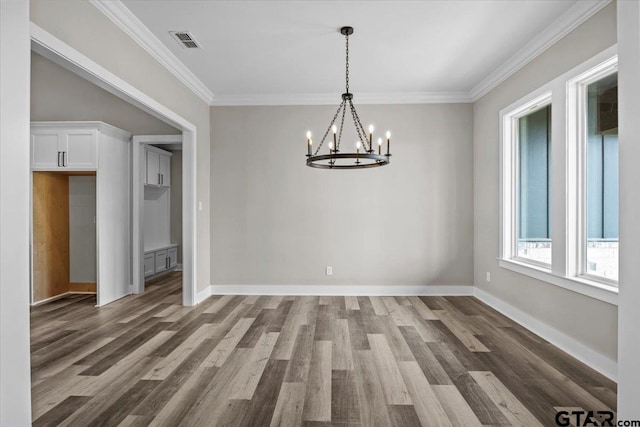 unfurnished dining area with dark hardwood / wood-style floors, crown molding, and a notable chandelier