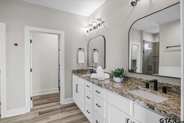 bathroom featuring walk in shower, vanity, and hardwood / wood-style flooring