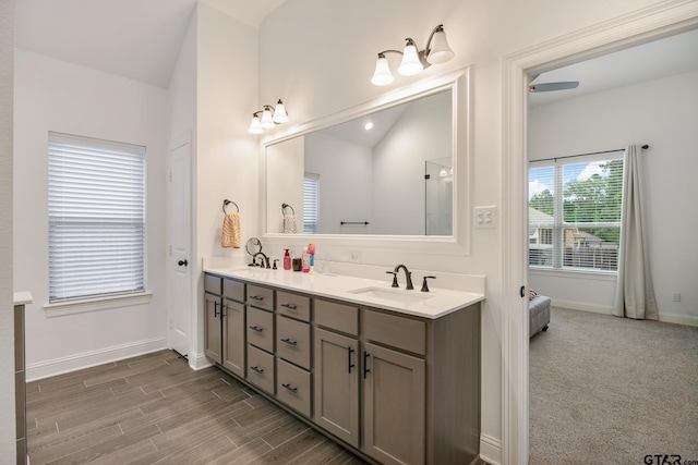 9157 Teal Flight Way, Tyler, TX 75703 - bathroom with baseboards, double vanity, lofted ceiling, and wood finished floors