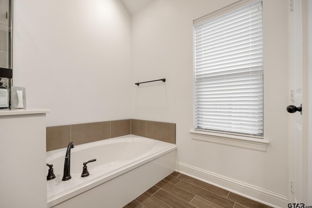 9157 Teal Flight Way, Tyler, TX 75703 - bathroom featuring a garden tub, baseboards, and wood finish floors