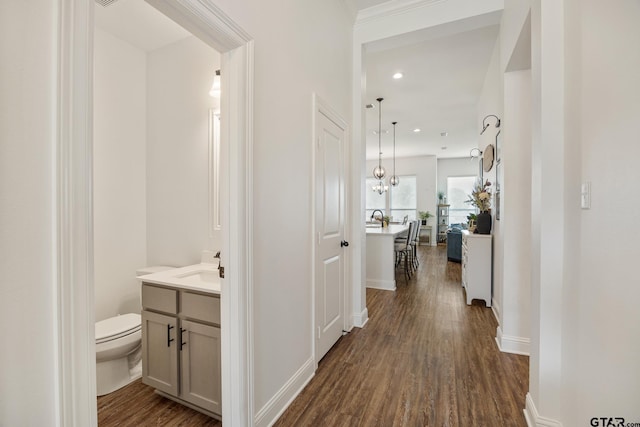 9157 Teal Flight Way, Tyler, TX 75703 - hallway featuring dark wood-type flooring, recessed lighting, baseboards, and a sink