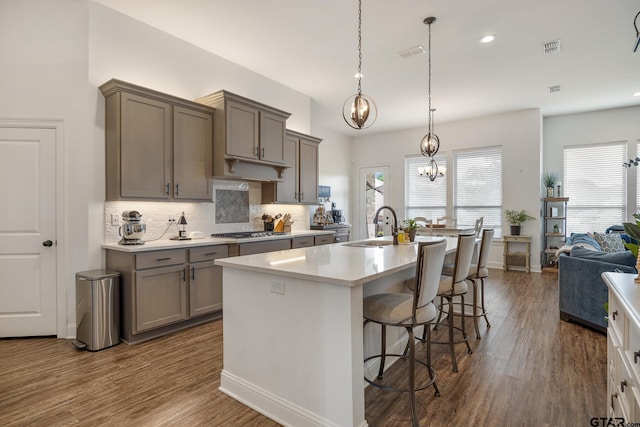 9157 Teal Flight Way, Tyler, TX 75703 - kitchen with a chandelier, stainless steel gas stovetop, dark wood-style floors, a sink, and tasteful backsplash