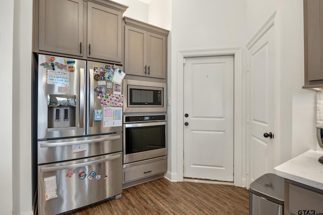 9157 Teal Flight Way, Tyler, TX 75703 - kitchen featuring stainless steel appliances, dark wood-type flooring, and light stone counters
