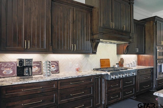 kitchen featuring ornamental molding, stainless steel gas cooktop, and dark brown cabinetry