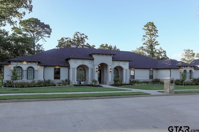 mediterranean / spanish house featuring a front lawn