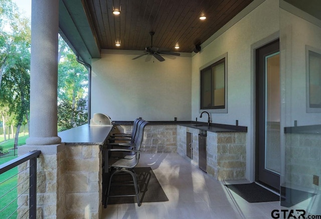 view of patio with ceiling fan and an outdoor wet bar