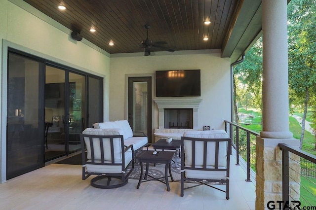 view of patio with an outdoor living space with a fireplace and ceiling fan