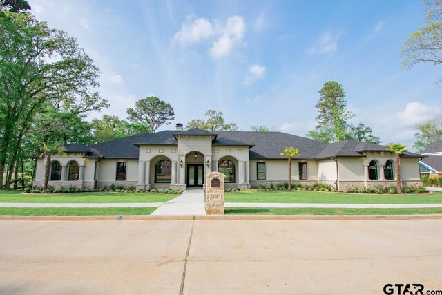 mediterranean / spanish-style home featuring a front yard and french doors