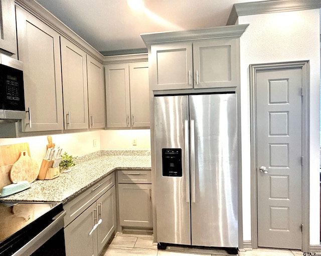 kitchen featuring appliances with stainless steel finishes, gray cabinets, and light stone countertops