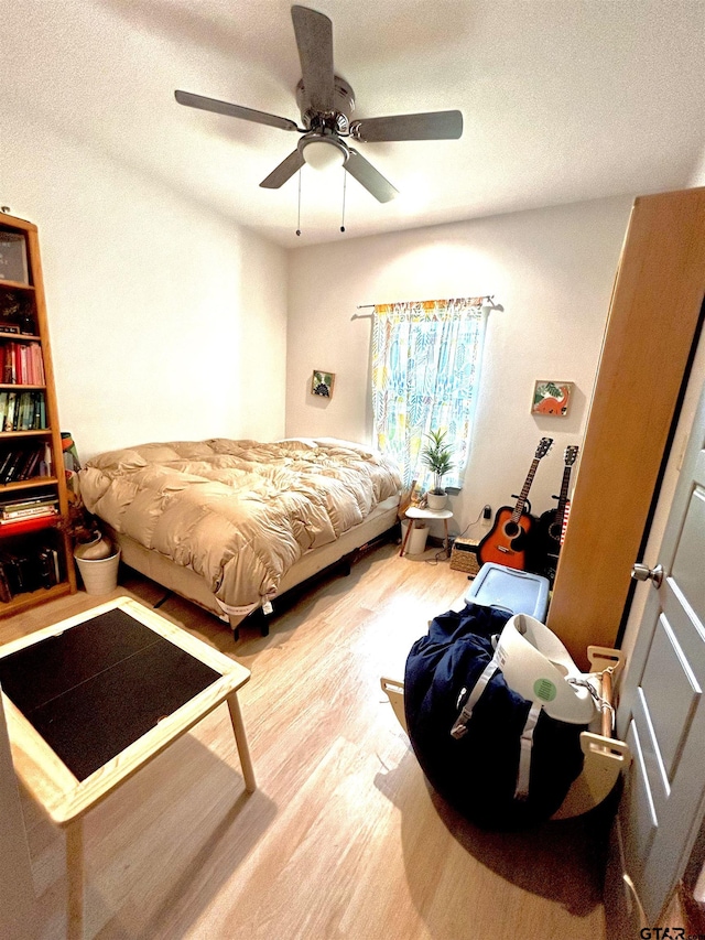 bedroom featuring hardwood / wood-style flooring, a textured ceiling, and ceiling fan