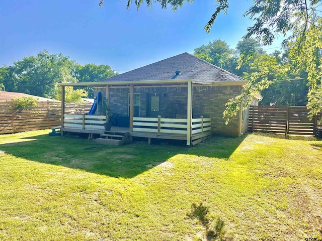 rear view of house featuring a yard and a deck