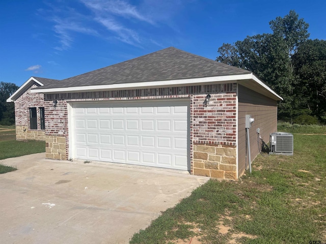 garage featuring cooling unit and a lawn