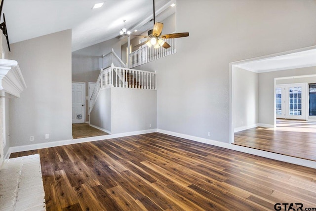 unfurnished living room featuring dark hardwood / wood-style floors, ceiling fan, high vaulted ceiling, and a brick fireplace