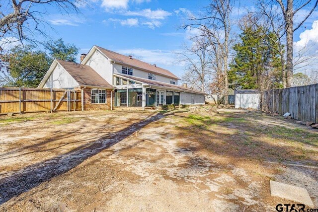 back of property with a storage shed