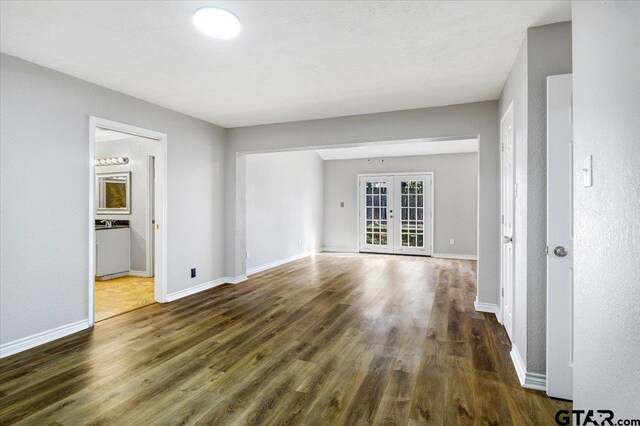 spare room with french doors and dark wood-type flooring