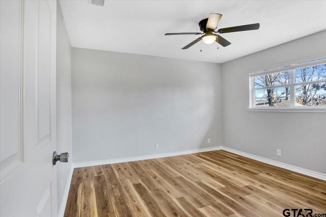 empty room with ceiling fan and hardwood / wood-style floors