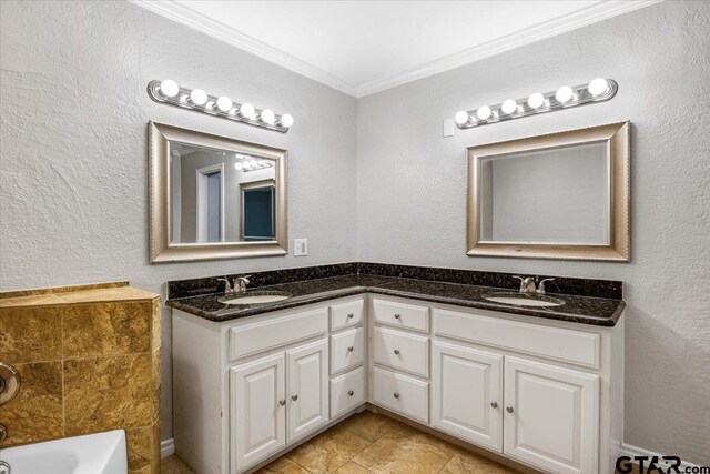 bathroom featuring a bathing tub, vanity, and crown molding