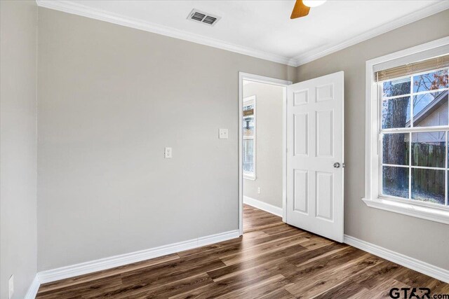 unfurnished room with ceiling fan, dark hardwood / wood-style floors, and ornamental molding